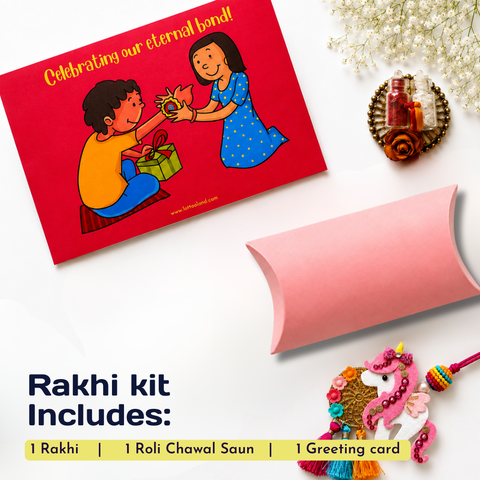 Rakhi kit flat lay on a white background featuring a red greeting card with a cartoon illustration, a pink paper envelope, and a pink and multicolor Rakhi charm. Text at the bottom reads 'Rakhi kit Includes: 1 Rakhi | 1 Roli Chawal Saun | 1 Greeting card'.