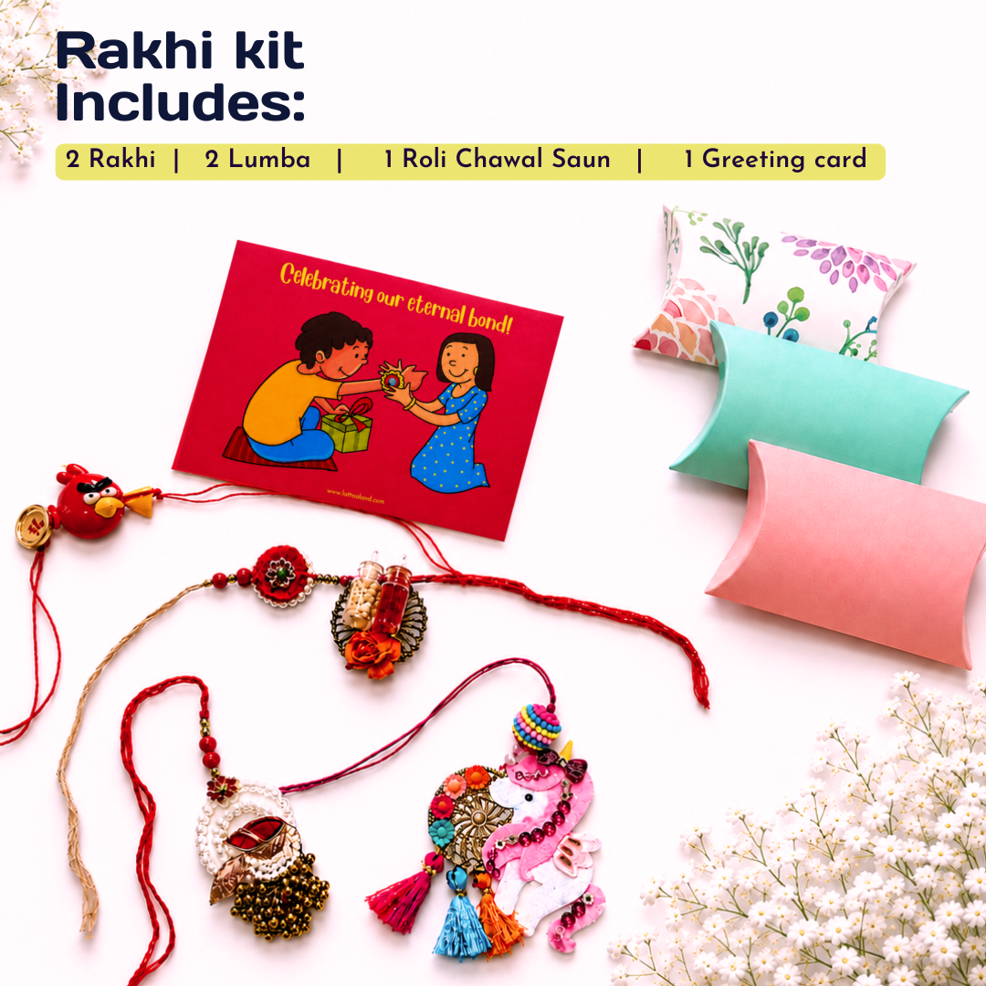 Rakhi gift kit contents arranged on a white background with a text header reading 'Rakhi kit Includes:'. Visible items include two embroidered Rakhi strands, a red greeting card, two decorative pillow boxes in pink and mint, and a small red lumba with a gold bead charm.