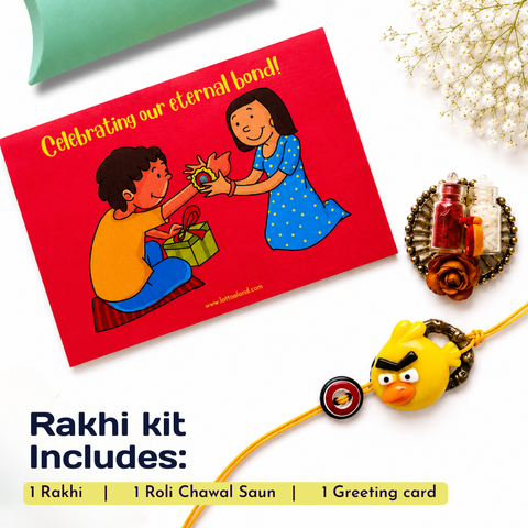 Rakhi gift set flat-lay on a white background featuring a red greeting card with a cartoon illustration, a yellow Rakhi with a bird-shaped charm, a decorative Roli Chawal Saun, and a text overlay detailing the kit contents.