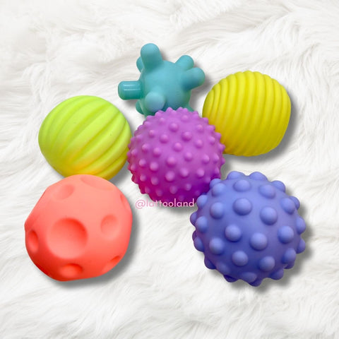 Toddlers enjoying safe and creative playtime with sensory balls, fostering social and sensory development.