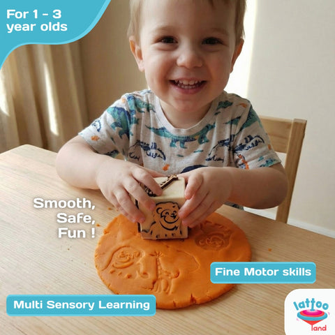 Child stamping forest animal shapes on play dough with wooden dice.